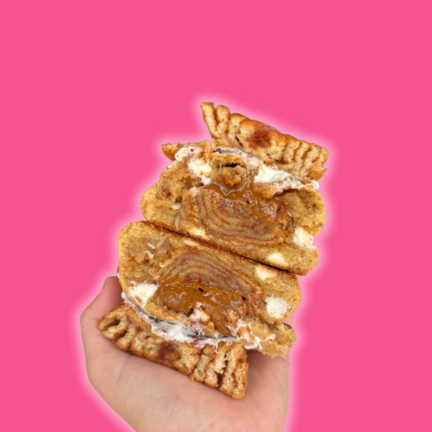 Dulce de leche cookie broken in half showing gooey caramel center and golden brown edges